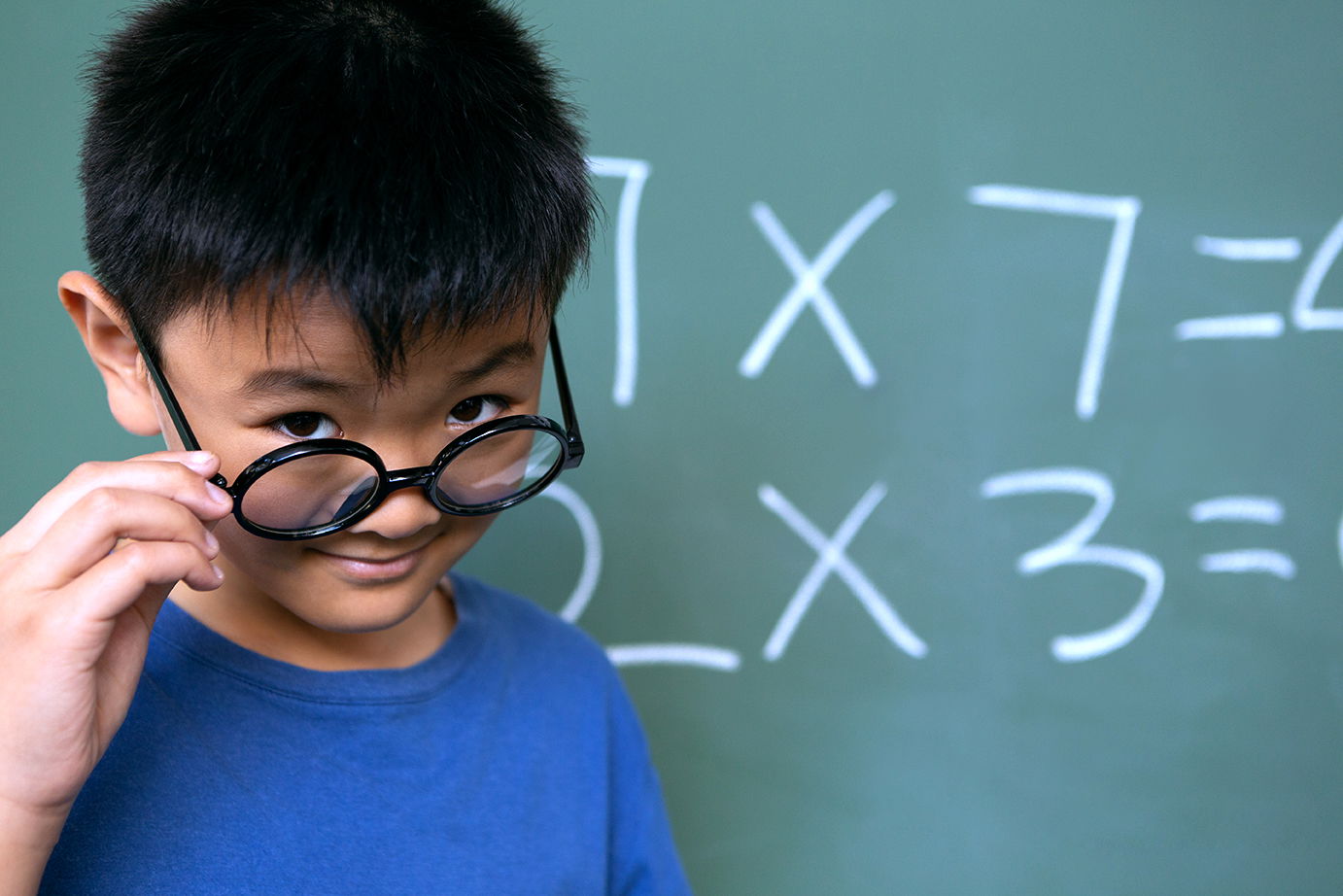 student next to a blackboard