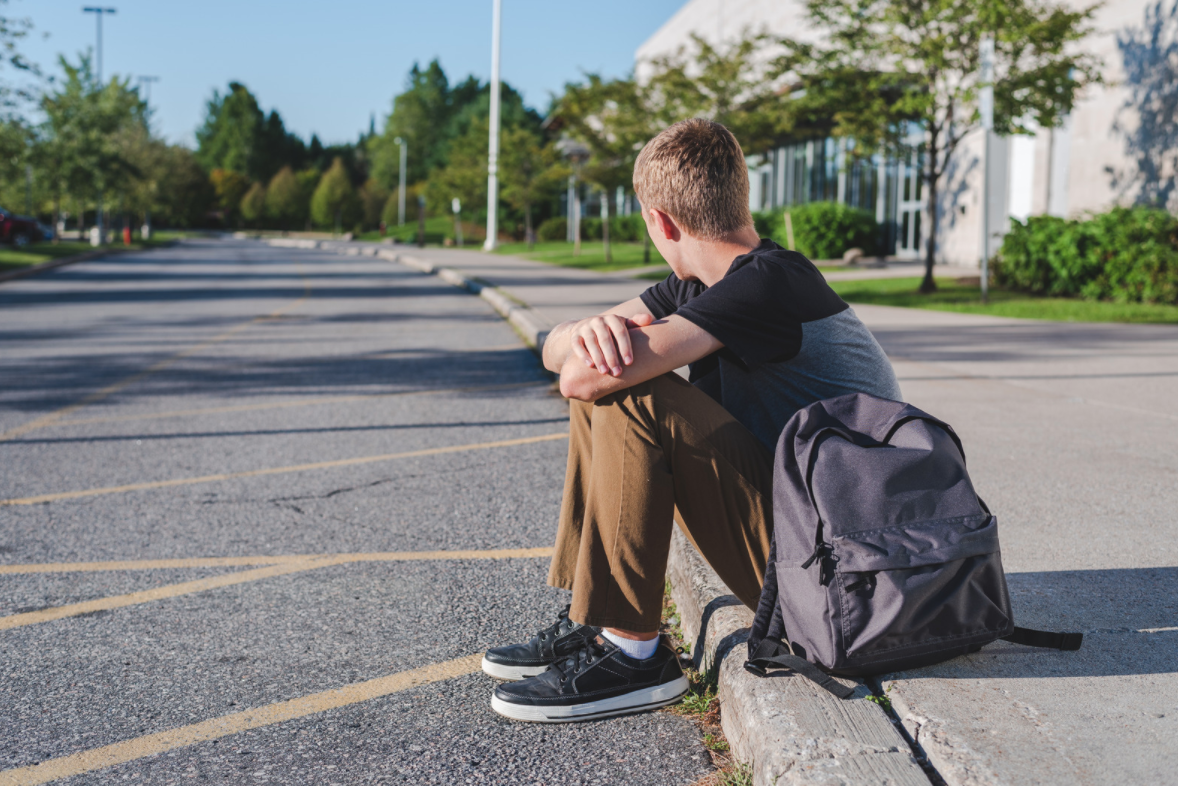 student sitting on kerb